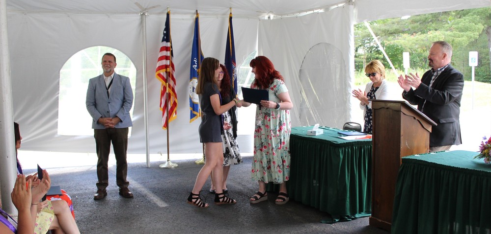 A student accepts her completion certificate