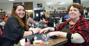 AEC cosmetology student manicures for cancer patient residence fundraising.