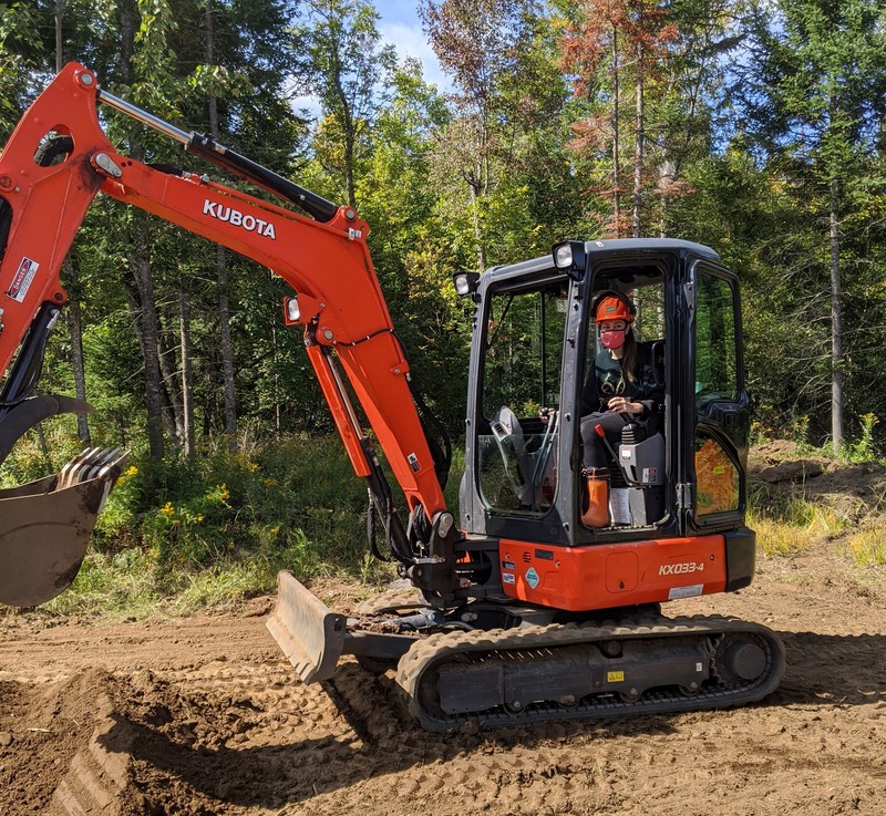 A student wears a mask while operating heavy machinery