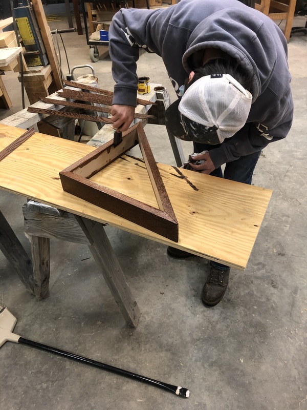 a student works on a wooden frame